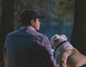 guy and his dog in the woods looking at scenery